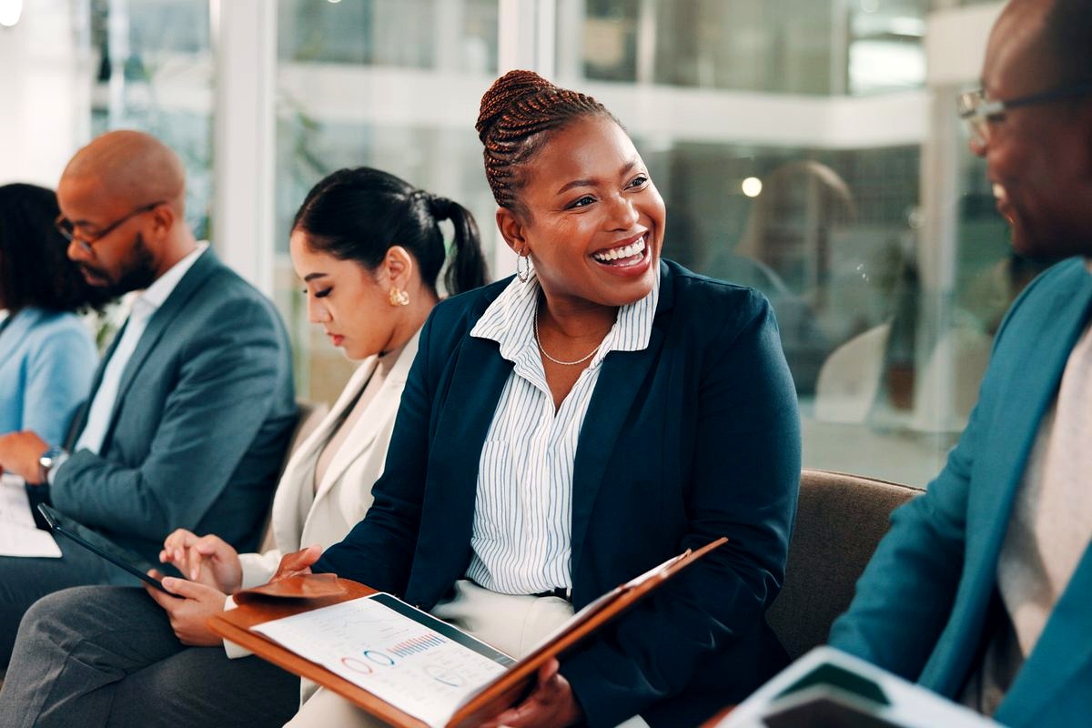 a diverse group of business professionals in a modern office setting engaged in what appears to be a team meeting or…